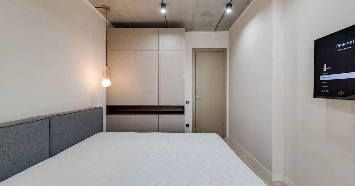 Une chambre minimaliste, moderne et épurée, avec un lit, des meubles et un éclairage ambiant.
